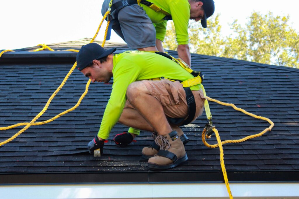 Two men on roof installing shingles