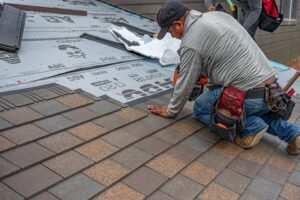 Roofing contractor installing Class A fire-rated asphalt shingles on a residential roof